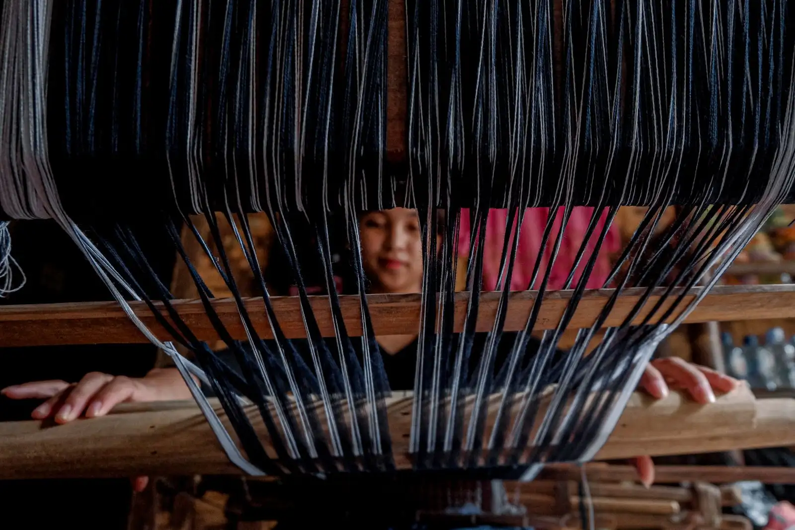 Artisan weaving natural fiber threads on a traditional loom